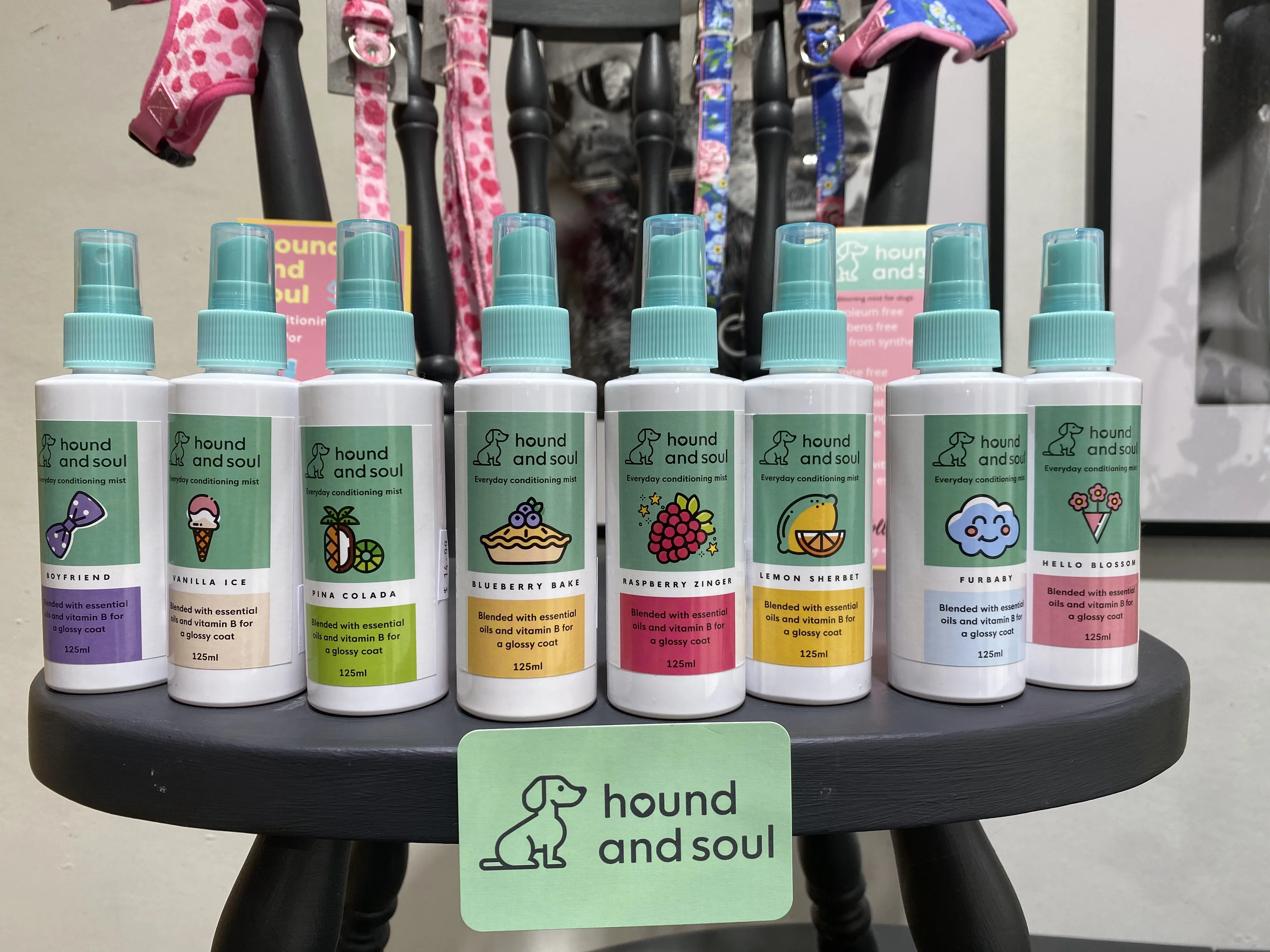 Display of hound and soul everyday conditioning mist bottles in eight scents, arranged on a black stool with the brand card